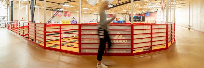 a female student is blurred in motion as she runs on a suspended track that runs along the wall of the sports and fitness center north gymnasium