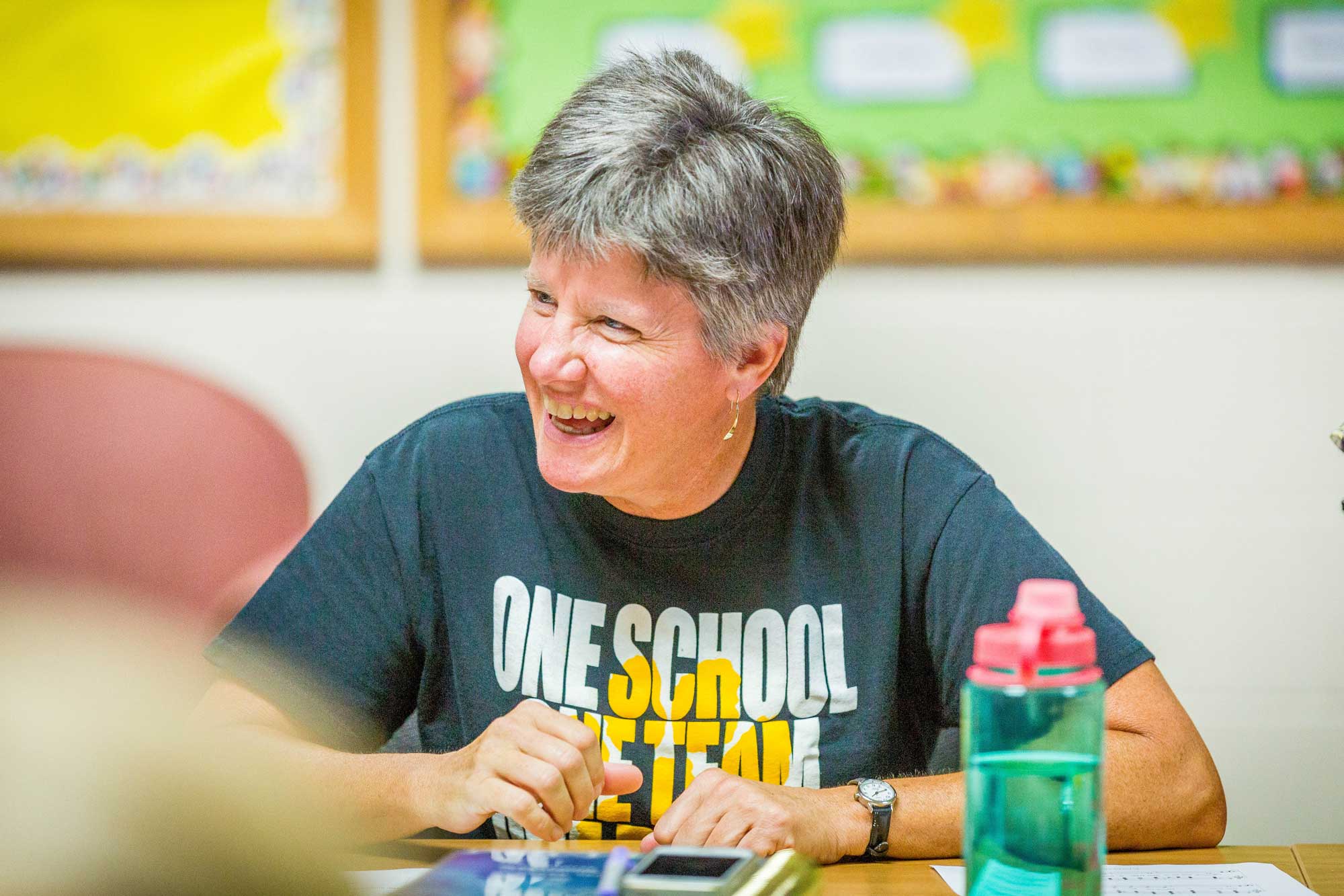 Professor laughing as she sits at table