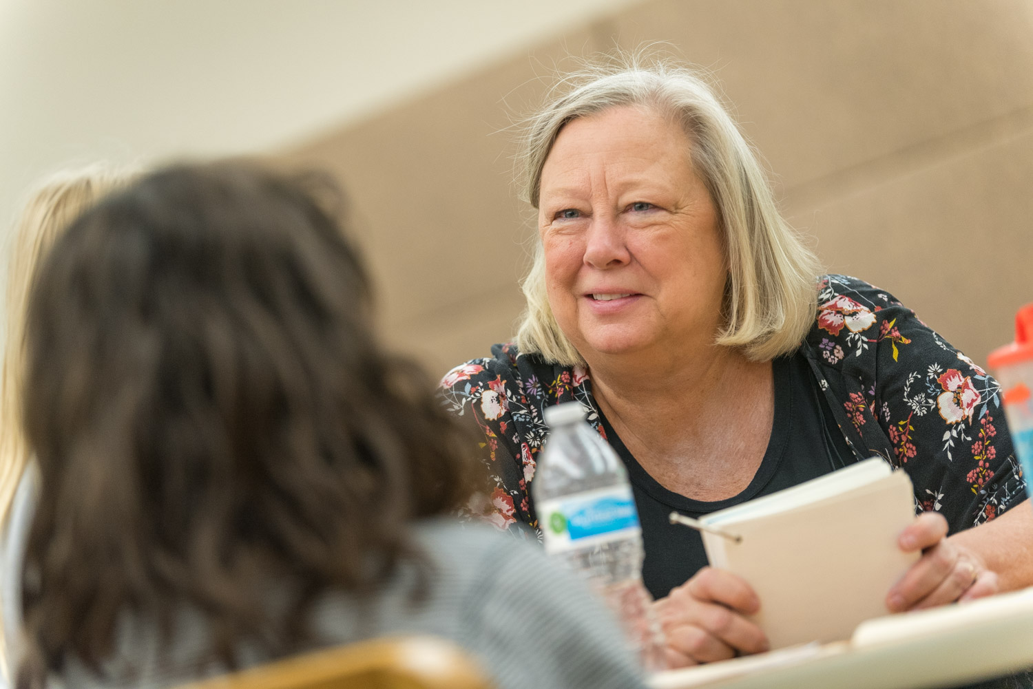 Teacher smiling at student at desk