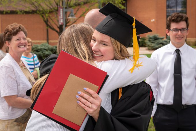 Graduate hugging family member