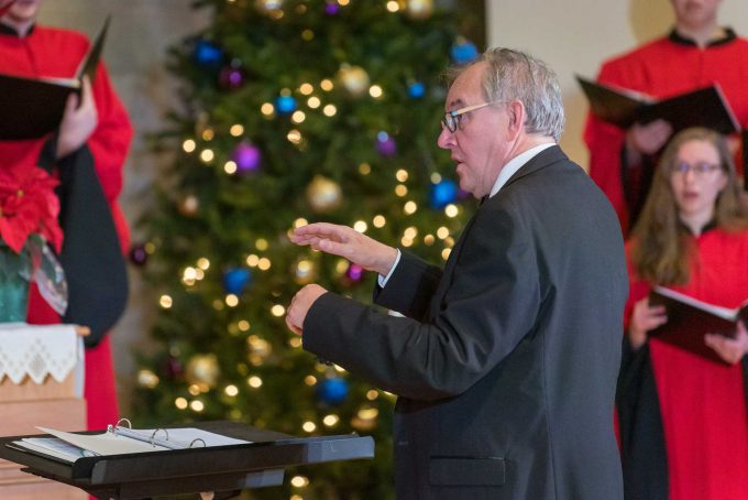 Music director waving arms in front of choir