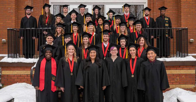 Graduates outside on steps posing for photo