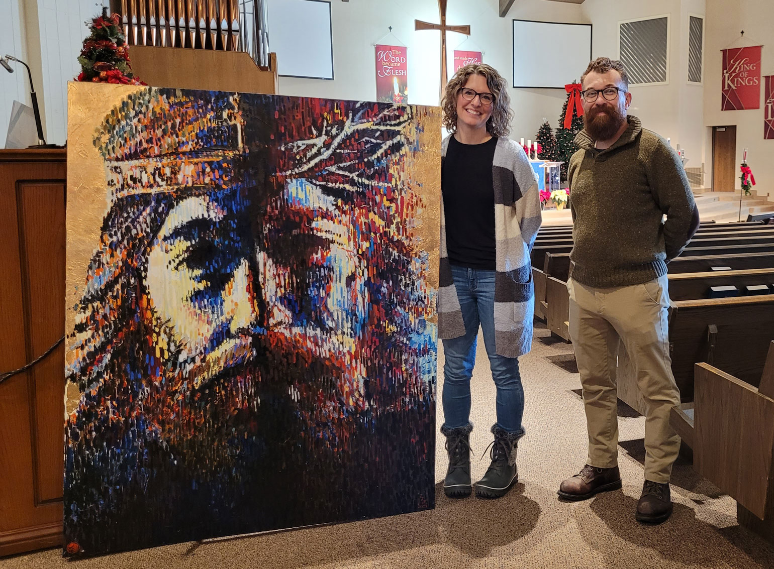 Jason Jasperson and a woman posing with the "Christus Paradox" painting