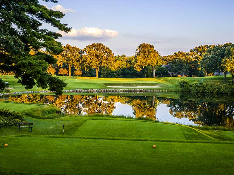 golf course hole tee box with water and trees