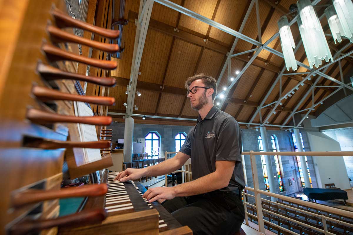 Boy playing the organ in the Trinity Chapel, Bethany Magazine