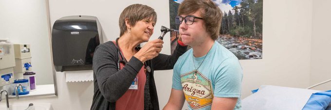 nurse examining students ears