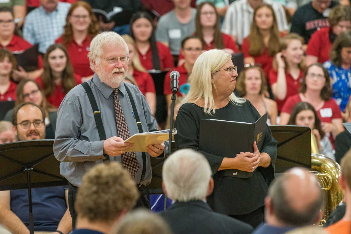 Two people, Professors Mark DeGarmeaux and Ann Fredrickson, delivering remarks about the choir and music program, Bethany Magazine