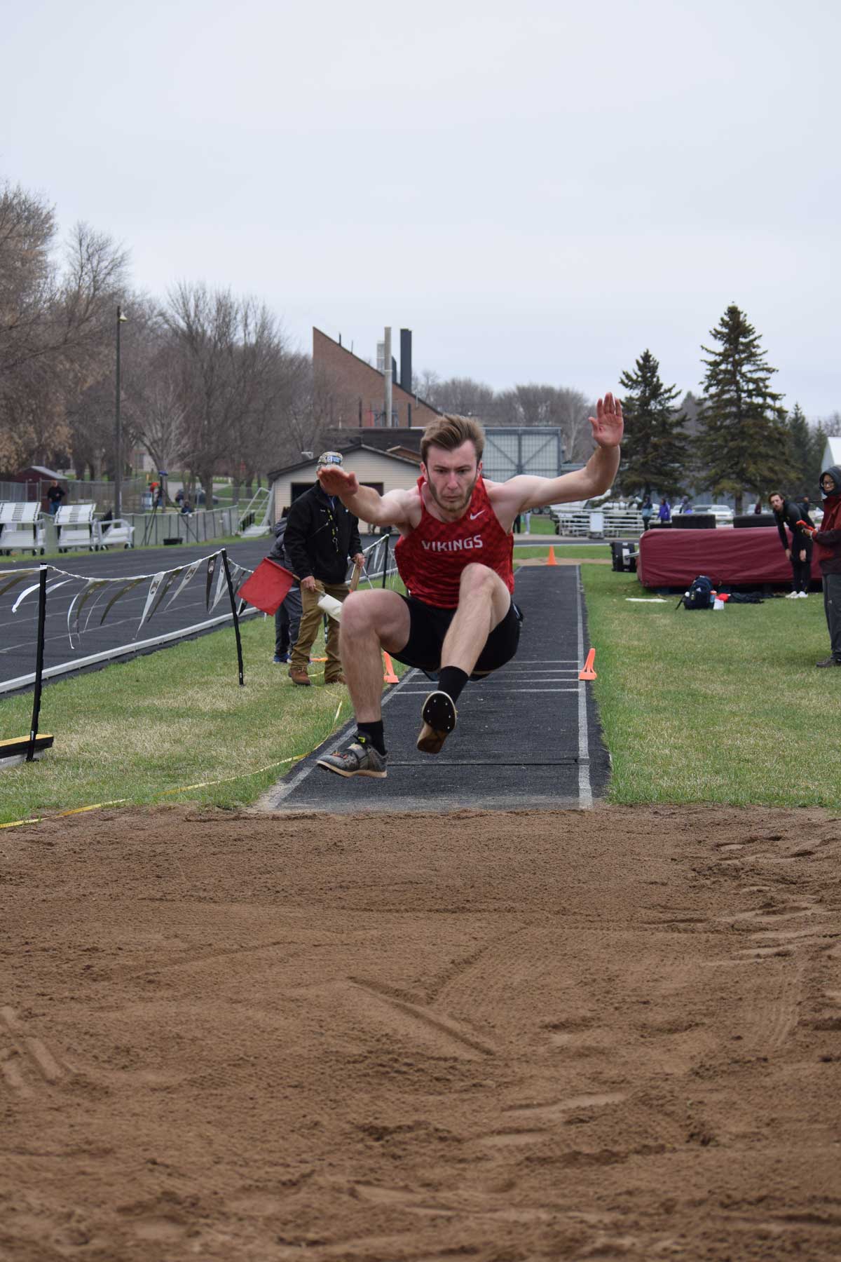 Boy jumping at an athletic conference outdoor track and field championship