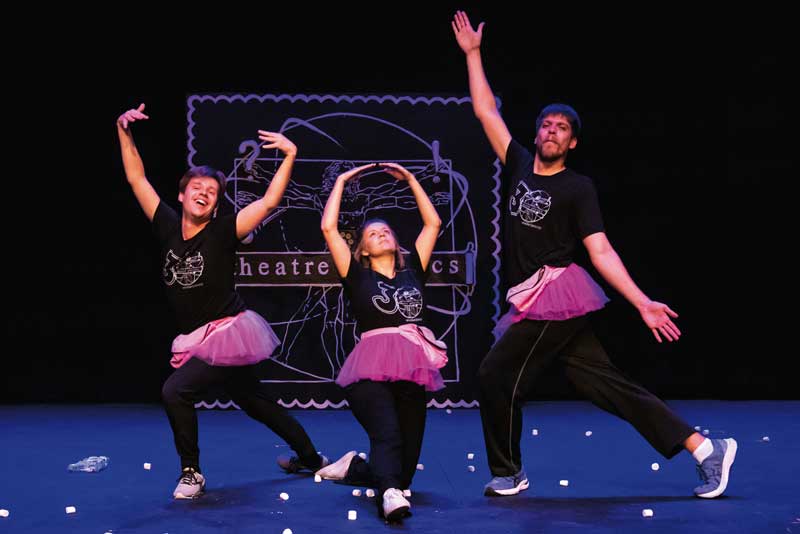 three people with ballerina tutus on posing on stage